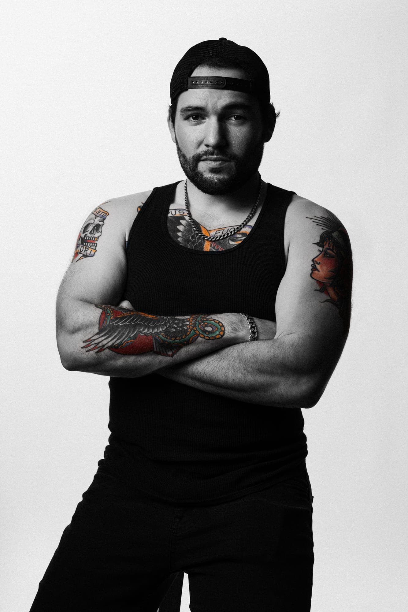 Black-and-white studio portrait of Jean Zamora, arms crossed